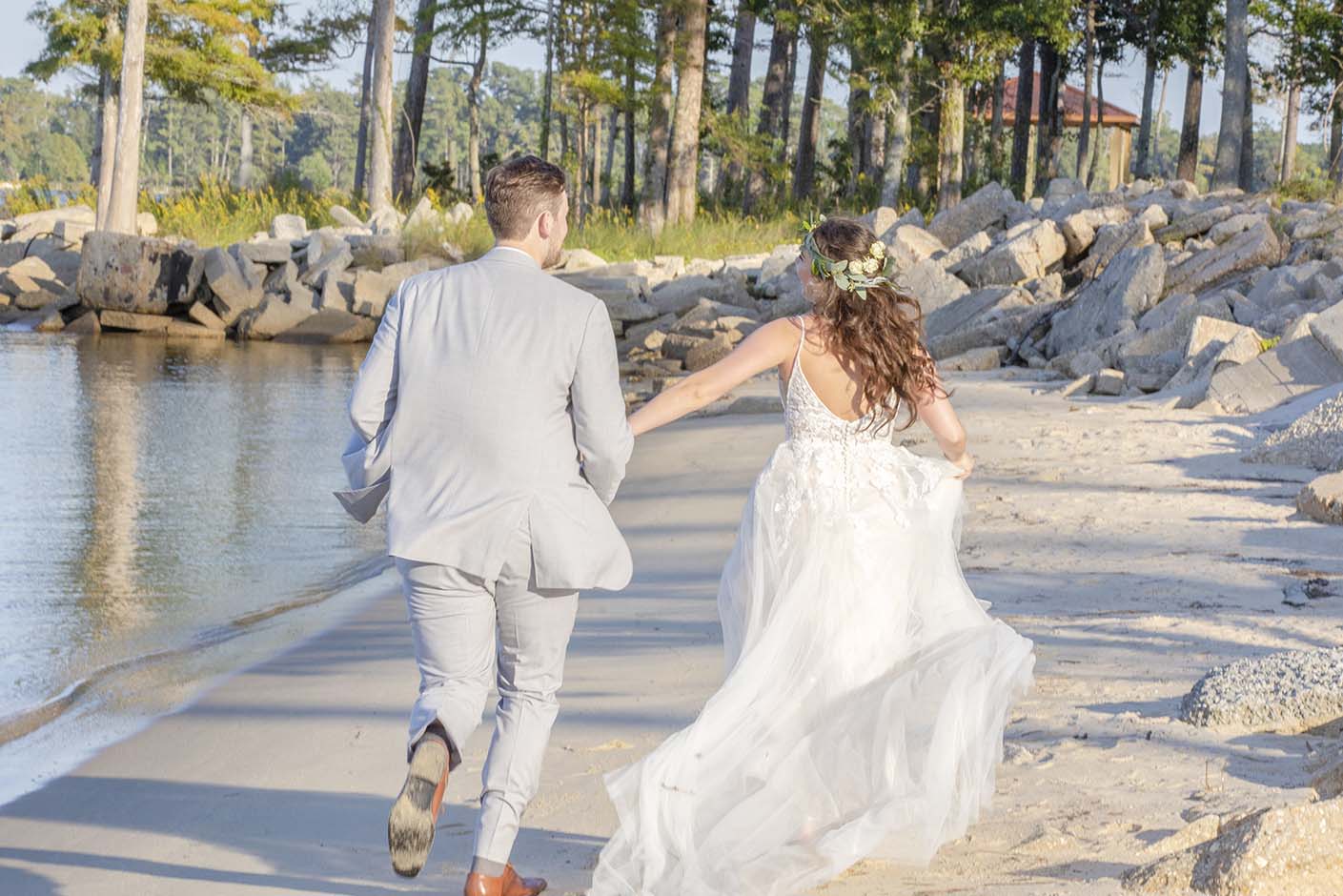 Bride and groom running on the beach